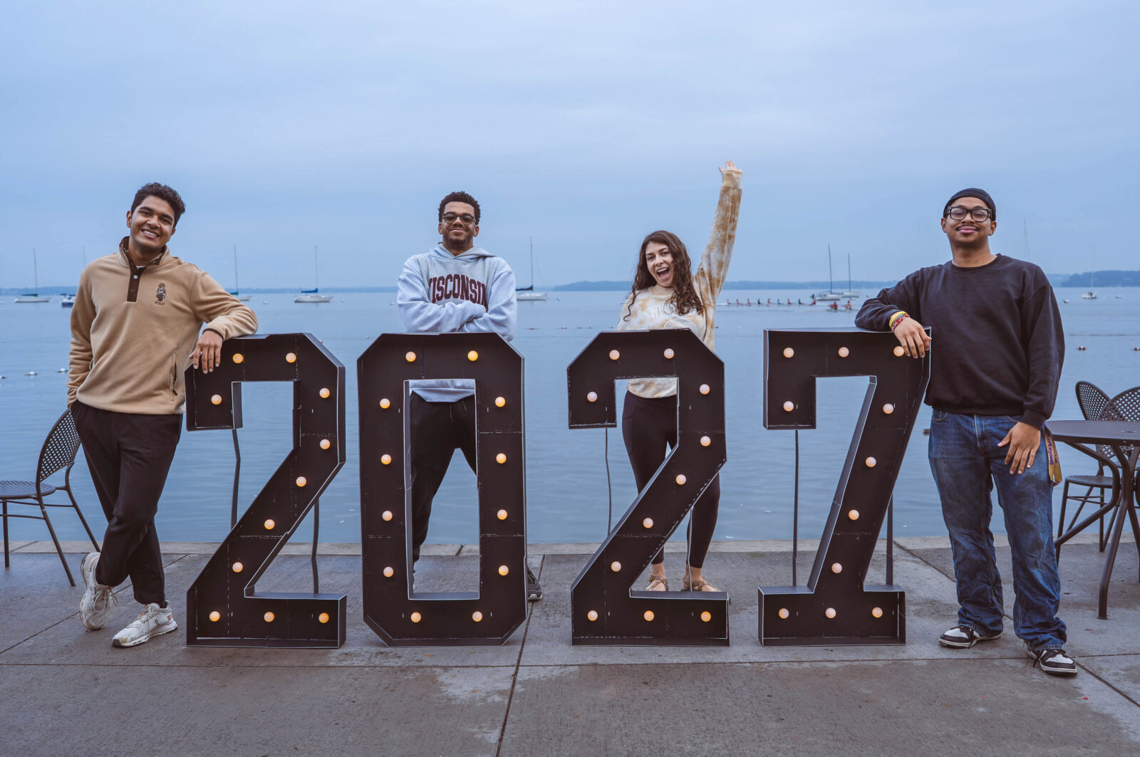 Senior class officers pose with a 2027 sign in front of Lake Mendota at the Memorial Union